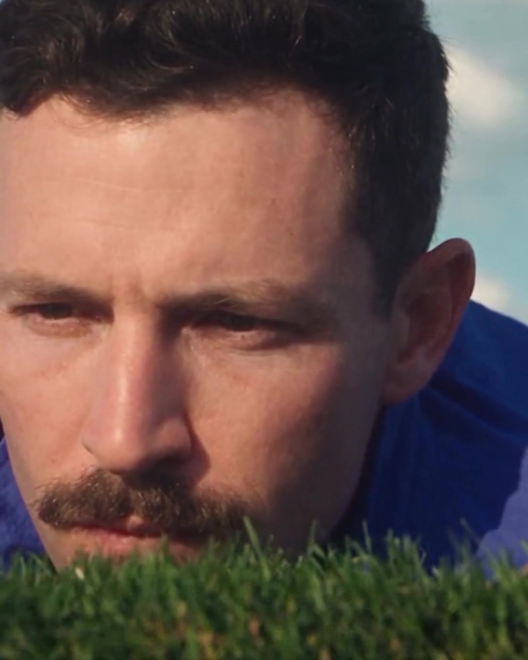 Close-up of the golfer at grass level, eye to eye with the turf